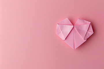 Poster - 
Minimalist pink background with a simple heart shape made of paper origami in a flat lay top view. Valentine's Day concept.
