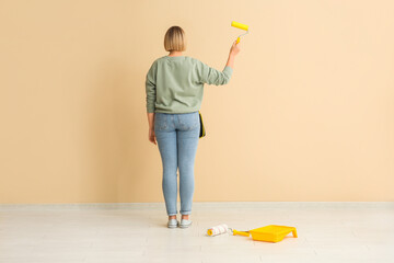 Wall Mural - Female decorator painting beige wall