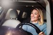 © Westend61 - Happy blond woman sitting inside car in parking