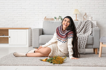 Poster - Beautiful young woman with bouquet of mimosa flowers on carpet at home