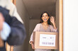© Hira/peopleimages.com - Wave, package and courier, woman or delivery for shipment, goodbye and online shopping. Happy, front door or retail for import logistics from female person, ecommerce or customer for cargo goods