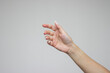 © Janeberry - A woman's hand is open and holding something like a bottle. Gesture isolated on gray background. The girl gives some object. Product presentation concept or mockup with copy space. Advertising