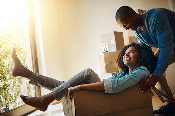 Wall Mural - Couple, happy and push box in new home for moving, real estate or property investment in living room. Lens flare, black man and young woman with cardboard for fun, mortgage or celebration in house