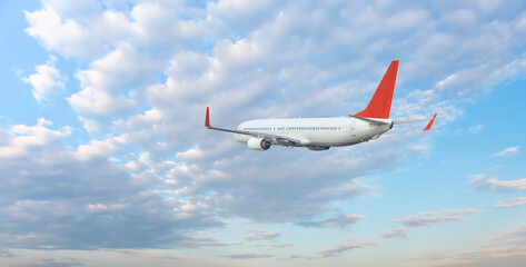 Wall Mural - White passenger airplane flying in the sky amazing clouds in the background - Travel by air transport