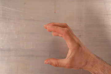 Wall Mural - A hand makes a gesture of holding something small