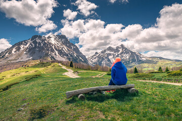 Wall Mural - Traveler enjoying the mountains, pausing on a bench