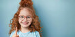 © Ninaveter - cute red-haired little girl with glasses standing on blue background with index finger raised up