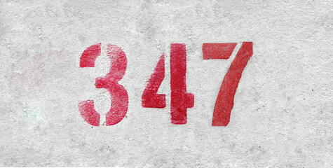 Red Number 347 on the white wall. Spray paint.