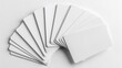 © konlawat - Multiple blank white credit cards arranged in a fan shape, casting subtle shadows on a pure white background, with sharp edges and glossy surfaces