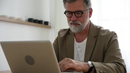 Wall Mural - Mature businessman ceo trader using computer, typing, working in modern office, doing online data market analysis, thinking planning tech strategy looking at laptop with copy space.