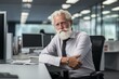 © juliars - Portrait of a mature businessman with a beard seated confidently in an office environment