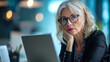 © Maestro - Thoughtful mature businesswoman at desk with laptop in modern office
