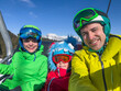 © Sergey Novikov - Smiling family on ski lift, snowy mountains in the background