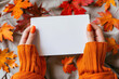 © Klay - woman holding a blank white card with colorful fall leaves background