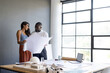 © Wavebreak Media - Architects reviewing blueprints in office, discussing project details near window, copy space