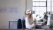 © Wavebreak Media - Using VR headset, woman working at desk in modern office environment, copy space