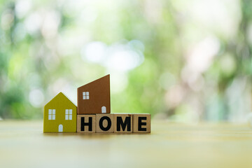 Poster - Home model placed on wood block of HOME against natural background with copy space