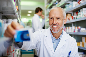 Canvas Print - Box, medicine and happy man in pharmacy for healthcare, wellness and service for retail. Pharmacist, mature and package for pills or supplements in hospital for inspection, information or check label