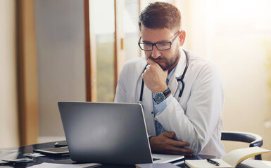 Male person, doctor and laptop with thinking, ideas and planning in office as medical professional. Man, pediatrician and diagnosis, telehealth and technology for patient records, medicine or surgery