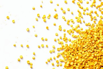 Poster - A closeup photo captures bright yellow plastic granules scattered across a white surface