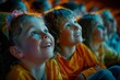 © Elmira - Two children, a boy and a girl, sit in a theater, their faces illuminated by the screen, as they watch a movie. They appear to be captivated by what they are seeing