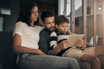 Poster - Tablet, family and parents with kid on sofa for learning, education and bonding. Digital technology, mother and father with child in home living room for streaming movie, video and watch cartoon