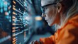 © familymedia - An engineer, wearing an orange work suit and hard hat, carefully monitors and analyzes data on multiple high-tech screens, highlighting the complexity and precision of her responsibilities.