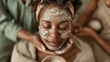 © familymedia - A woman with closed eyes receiving a facial treatment in a tranquil setting, suggesting relaxation, self-care, and a luxurious spa experience for rejuvenation and care.