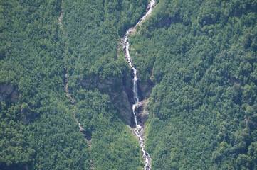 Sticker - View of the mountain covered with forest and waterfall. The natural landscape. View from above.