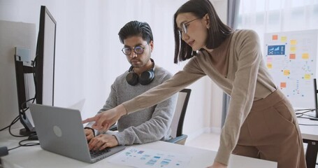Young adult Asian male, female software developer coding program on desktop computer. Man, woman work from home, remote working, freelance programmer job, smart digital nomad lifestyle concept