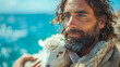 © Design Resources - A depiction of Jesus by the ocean, with striking blue eyes, gently cradling a baby lamb.