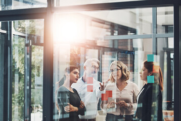 Poster - Woman, team and planning with discussion by glass board with sticky notes, questions and ideas with brainstorming. Coach, training and group by wall, synergy or collaboration with strategy in office