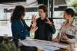 © qunica.com - Young business partners collaborating on project plans and analyzing data at an urban coffee bar. They are focused on creating new marketing and growth strategies.