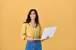 © Stock 4 You - 20s young smiling freelance businesswoman, middle eastern positive woman holding laptop computer looking at camera. Student female girl in casual clothes using pc gadget isolated on yellow background