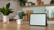 © Iana - An iPad mockup with a white screen on a kitchen counte with a blurred modern kitchen setting