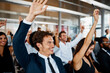 © StarDweller/peopleimages.com - Happy, business people and meeting with question for presentation, interaction or engagement at office. Team or group of employees with hands raised or smile for collaboration, answer or conference