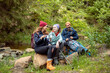 © Davor - Family hiking trip in forest, taking a break and enjoying hot drinks by a stream