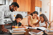 © DoneDeal/peopleimages.com - Helpful parents, children and books with homework for learning or guidance on kitchen table. Mother, father and young kids studying together for education, knowledge or childhood development at house