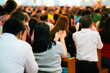 © Galina - Woman folded hands and people pray in church during Friday Mass