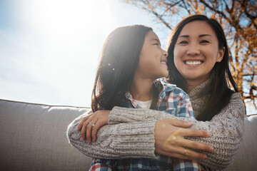 Asian family, mom and daughter on sofa in patio for bonding or support, love and growth for child development. Parent, kid and smile with hug for childhood memories, trust and care together at home