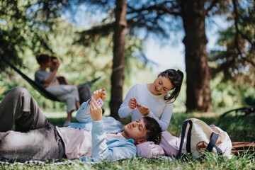 Poster - Young friends enjoying a relaxing day at the park, playing cards and chatting