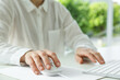 © New Africa - Woman working with wired mouse and computer keyboard at white table indoors, closeup