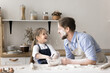 © fizkes - Cheerful preschooler kid girl playing with father while cooking together, stains him with flour laughing cooking in the messy smeared kitchen at home. Family pastime, games and communication, culinary