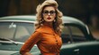© AberrantRealities - a woman in an orange dress and glasses standing next to an old car
