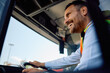 © Drazen - Below view of happy bus driver driving city bus.