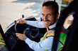 © Drazen - Happy bus driver inside vehicle cabin looking at camera.