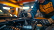 © Mars0hod - A close-up shot of a mechanics hand holding a tool while inspecting a car engine in a workshop