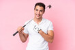 © luismolinero - Young golfer player man isolated on pink background pointing to the side to present a product