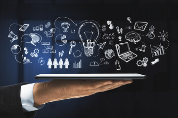 Aufkleber - A hand holding a digital tablet with various drawn icons floating above it against a dark background, illustrating the concept of ideas and technology