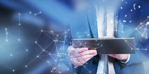 Poster - A businessman using a tablet with network connection graphics overlay, digital concept on a blurred blue background